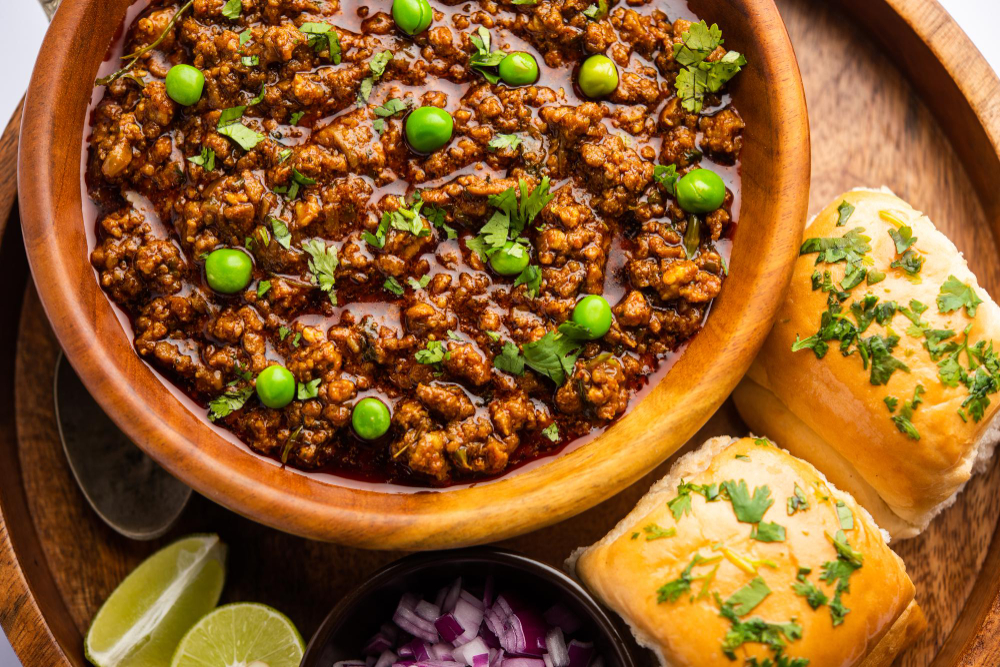 mutton-kheema-pav-indian-spicy-minced-meat-served-with-bread-kulcha-garnished-with-green-peas-moody-background-selective-focus (1)